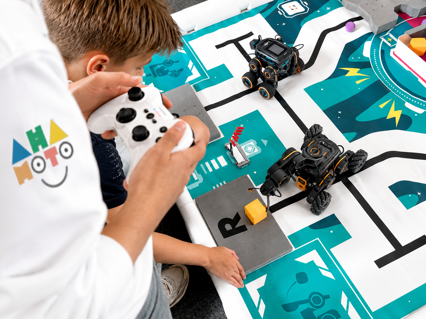 Kind bestuurt een robot op de Ahamoto-speelmat tijdens de club